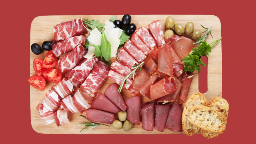 Charcuterie arranged on a wooden cuting board. 