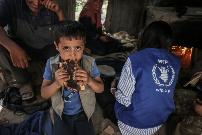 A young boy eats bread from WFP in Gaza, where more than one million people face catastrophic hunger. 