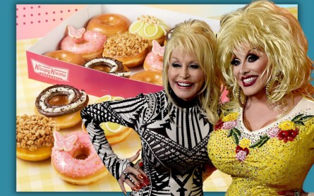Dolly Parton and a Dolly Impersonator stand in front of a picture of her new Krispy Kreme doughnut line.